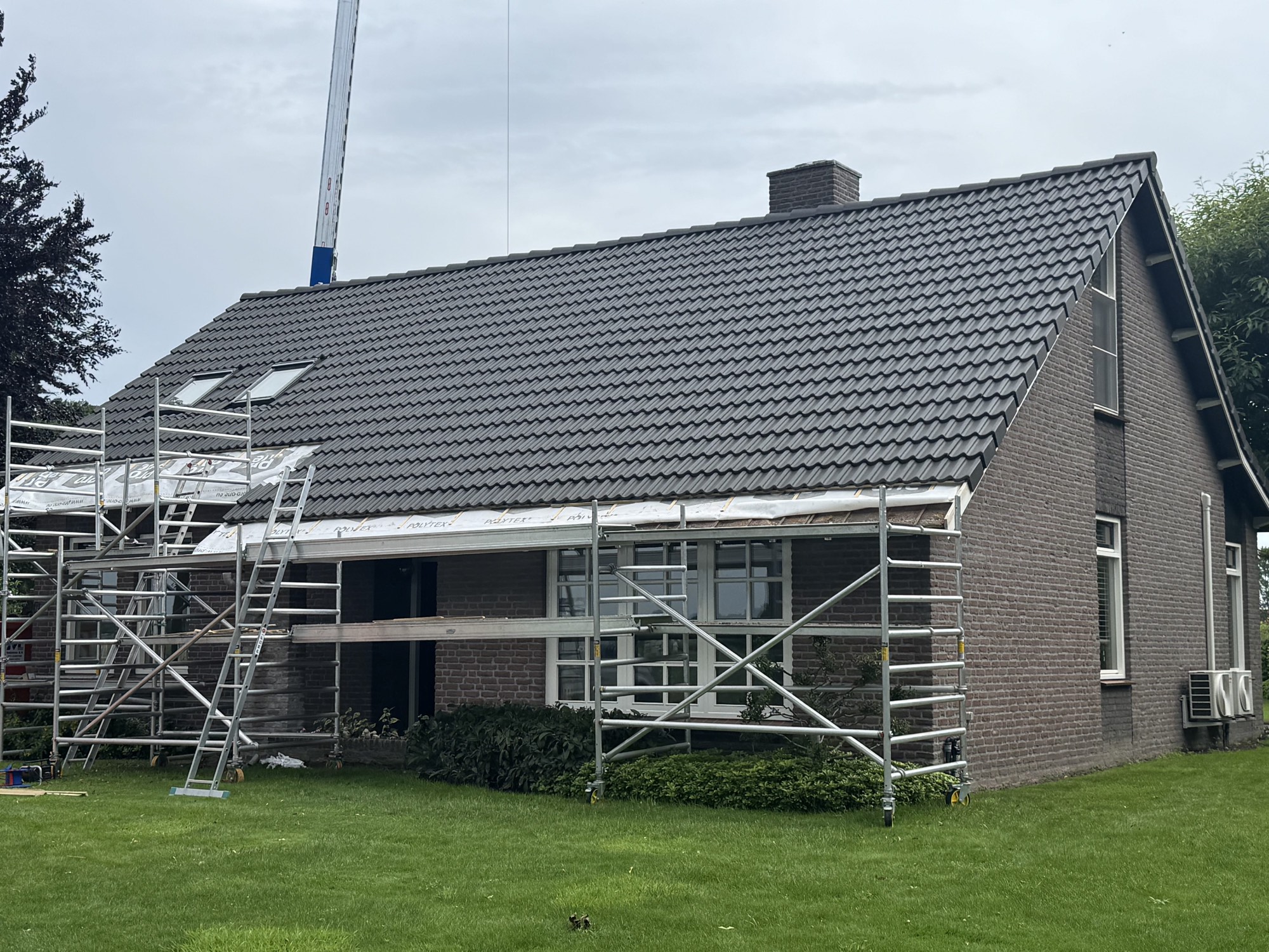 Hellend dak van nieuwe pannen voorzien